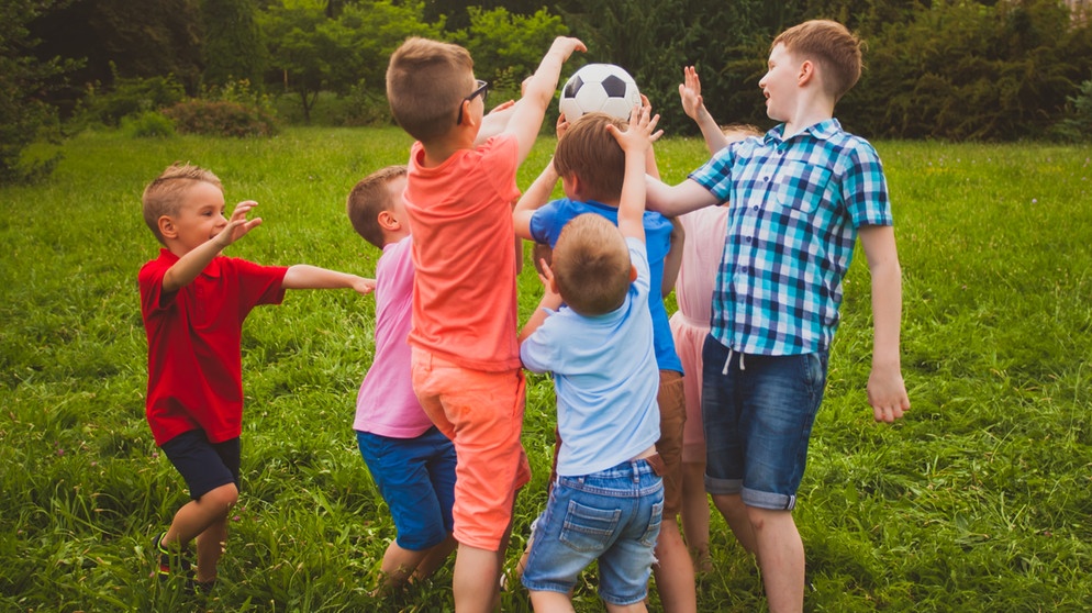 Eine Gruppe Kinder spielt Ball in einem Garten. Die Fähigkeit zur Empathie entwickelt sich bei Kindern über die Jahre. Eltern können diese Entwicklung unterstützen, etwa in dem sie ihren Kindern beibringen, über Gefühle und Bedürfnisse zu sprechen.   | Bild: colourbox.com